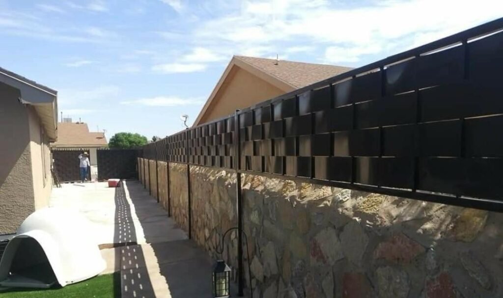 Metal privacy fence on rock wall in El Paso TX